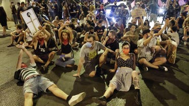 Israeli protesters sit on the ground during a demonstration against the Israeli prime minister and against the second nationwide lockdown imposed by the government in a bid to stem the increase of coronavirus cases, in Tel Aviv, October 1, 2020. (AFP)