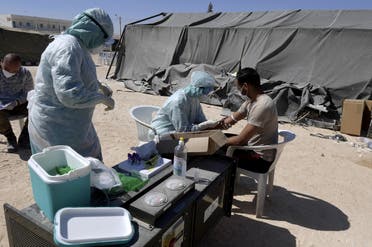 A nurse takes a blood sample from a man before a COVID-19 test at a military hospital in the town of El-Hamma, in Tunisia’s southwestern Gabes governorate, August 26, 2020. (AFP)