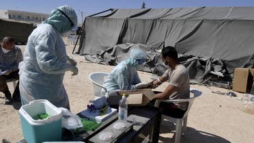 A nurse takes a blood sample from a man before a covid-19 test at a military hospital in the town of El-Hamma, in Tunisia’s southwestern Gabes governorate, August 26, 2020. (AFP)