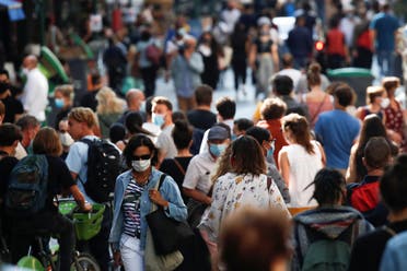 People wearing protective face masks walk in a busy street in Paris. (File photo: Reuters)