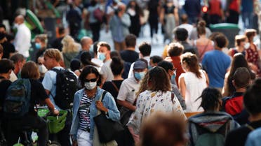 People wearing protective face masks walk in a busy street in Paris. (File photo: Reuters)