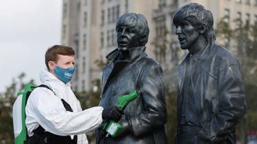 A man disinfects a statue of the Beatles amid the outbreak of the coronavirus disease (COVID-19), in Liverpool, Britain October 1, 2020. (Reuters)
