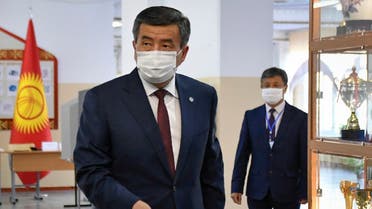 Kyrgyz President Sooronbay Jeenbekov wearing a face mask casts his ballot at a polling station during parliamentary election in Bishkek on October 4, 2020, amid the ongoing coronavirus pandemic. (Vladimir Voronin/Pool/ AFP)