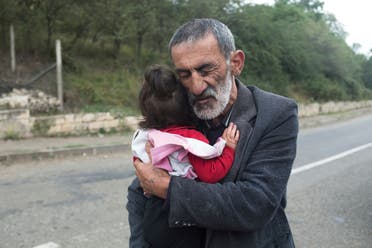 A local resident holds his granddaughter in the Hadrut province of Nagorno-Karabakh on Oct. 1, 2020. (AP)
