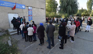 People queue outside a polling station during Kyrgyzstan's parliamentary election in the village of Besh-Kungey outside Bishkek on October 4, 2020, amid the ongoing coronavirus pandemic.  (Vyacheslav Oseledko/AFP)