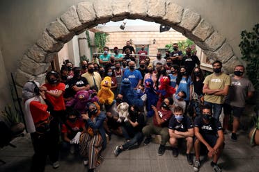 The staff of the children program Ahlan Simsim pose for a group picture with their puppets during the filming of a scene on the set of the show in a studio in Amman, Jordan. (Reuters)