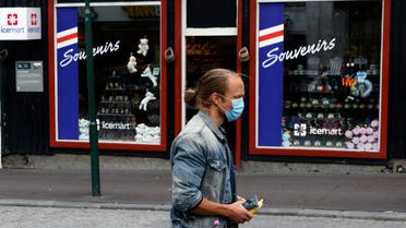 A man with a face mask walks past a tourist shop as the outbreak of the coronavirus disease (COVID-19) continues in Reykjavik, Iceland, September 3, 2020. (Reuters)