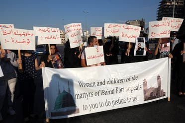 People carrying placards and pictures of family members and friends killed in the massive August 4 explosion at Beirut's seaport, gather there two months after the disaster. (AFP)