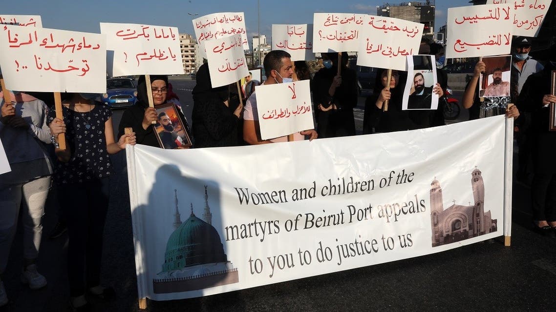 People carrying placards and pictures of family members and friends killed in the massive August 4 explosion at Beirut's seaport, gather there two months after the disaster. (AFP)