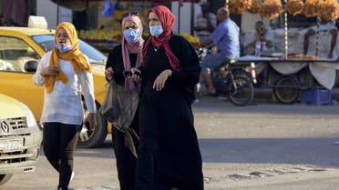 Tunisian women wear face masks for protection against the novel coronavirus at a market in the southwestern Tunisian town of Gabes on August 26, 2020, as cases of infection surge there. (AFP)
