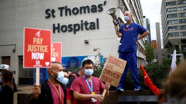 An NHS staff member holds a megaphone during a protest asking for a pay rise, amid the spread of the coronavirus disease (COVID-19), in London. (Reuters)