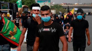 Shia pilgrims wearing face masks as a precaution against the coronavirus while marching to the holy shrines of Imam Hussein and Imam Abbas ahead of the Arbaeen festival in Karbala. (AP)