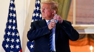 US President Donald Trump pulls off his face mask at the White House after returning from being hospitalized, Oct. 5, 2020. (Reuters)