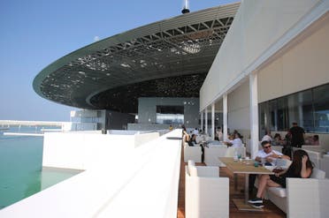 People sit in the cafe of the Louvre Museum, during the public opening day, in Abu Dhabi, United Arab Emirates, Saturday, Nov. 11, 2017. (AP)
