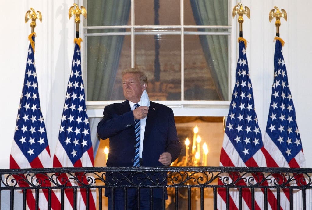US President Donald Trump removes his mask upon return to the White House from Walter Reed National Military Medical Center on October 05, 2020 in Washington, DC. Trump spent three days hospitalized for coronavirus. (AFP)