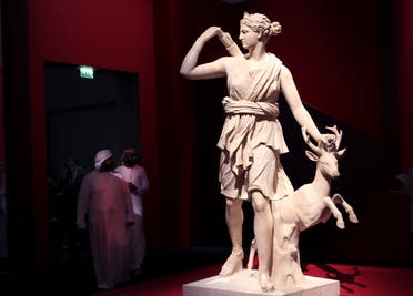 Emirati men passe by the The Diana of Versailles or Artemis of the hunter sculpture, Italy, 2nd Century CE, at the Louvre Museum in Abu Dhabi, United Arab Emirates, Tuesday, Dec. 19, 2017. (AP)