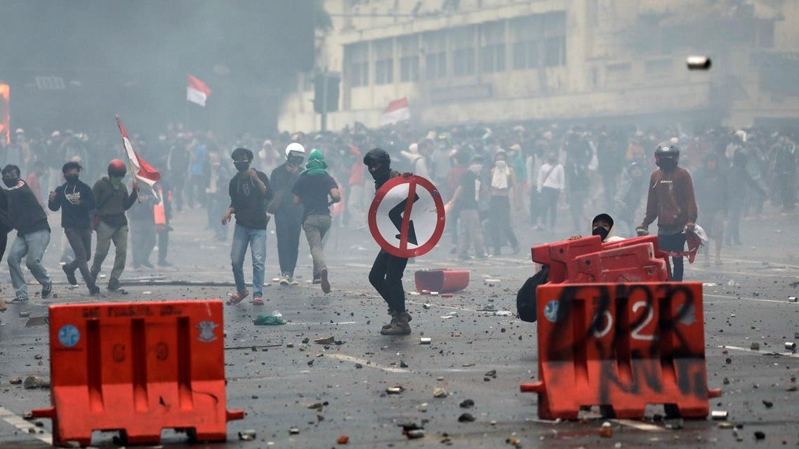 Demonstrators react behind a barricade as they protest against the government's proposed labour reforms in a controversial jobs creation bill near the Presidential Palace in Jakarta, Indonesia, on October 8, 2020. (Reuters)