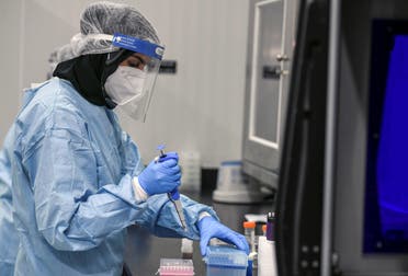 A medical worker wearing protective suit and face shield carries out tests at the Biogenix Laboratories, which performs COVID-19 detection tests, in Masdar City, Abu Dhabi. (Reuters)