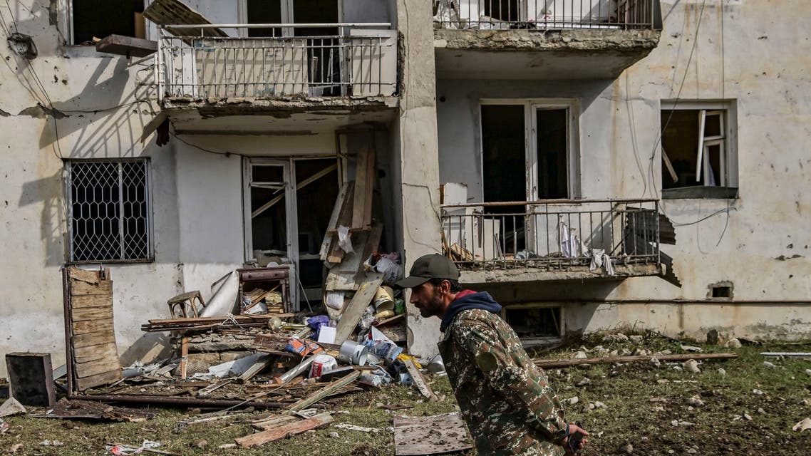 A man walks in front of a destroyed house after a late October 7th sheling in the breakaway Nagorno-Karabakh region's main city of Stepanakert. (AFP)