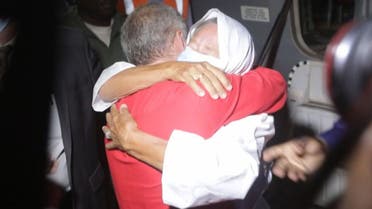 This video frame grab from an AFP video from October 8, 2020, shows French ex-hostage Sophie Petronin (R), who was released and flew to Bamako, hugging her son Sebastien Petronin (L) after she was reunited with him. (AFP)
