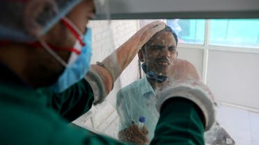 A healthcare worker collects a swab sample from a man amidst the spread of the coronavirus disease at a testing center, in New Delhi, India October 9, 2020. (Reuters/Anushree Fadnavis) 