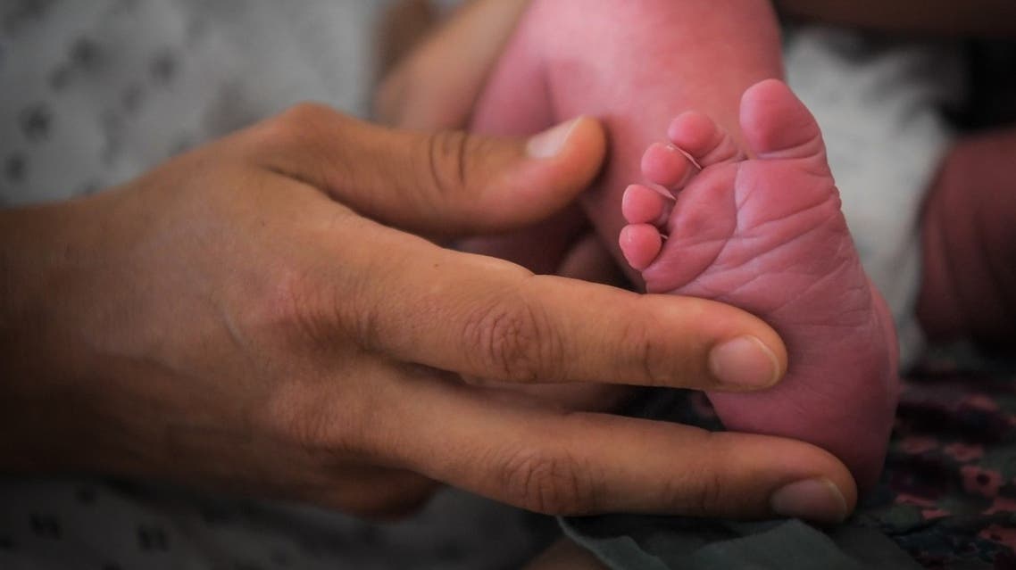 A file photo shows a mother holds the foot of her newborn baby on July 7, 2018 at the hospital in Nantes, western France. (Loic Venance/AFP)
