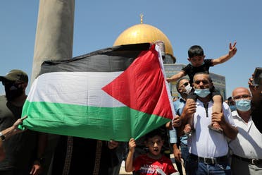 People hold a Palestinian flag during a protest against the United Arab Emirates, in Jerusalem's Old City, August 14, 2020. (Reuters)