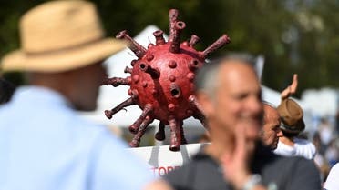 A giant mock-up of a coronavirus is seen during a demonstration against the German government's measures implemented to limit the spread of the coronavirus in western Germany, on September 20, 2020. (AFP)