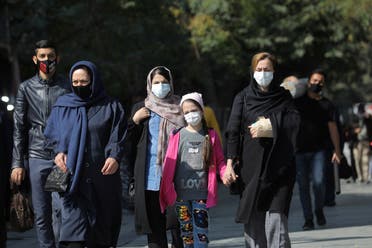 Iranians wearing face masks walk on a street after Iranian authorities made it mandatory for all to wear face masks in public following the outbreak of the coronavirus disease (COVID19), in Tehran Iran. (Reuters)
