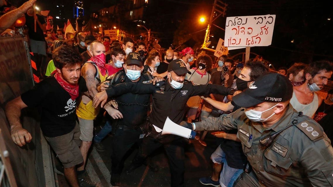 Israeli security officers try to block protesters during a demonstration against PM Netanyahu in the coastal city of Tel Aviv, October 10, 2020. (AFP/Emmanuel Dunand)