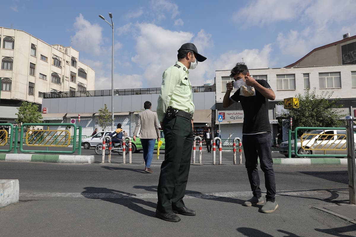 A police officer advises an Iranian man to wear a face mask following the outbreak of the coronavirus disease  in Tehran. (Reuters)