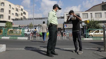 A police officer advises an Iranian man to wear a face mask after Iranian authorities made it mandatory for all to wear face masks in public following the outbreak of the coronavirus disease (COVID19), in Tehran. (Reuters)