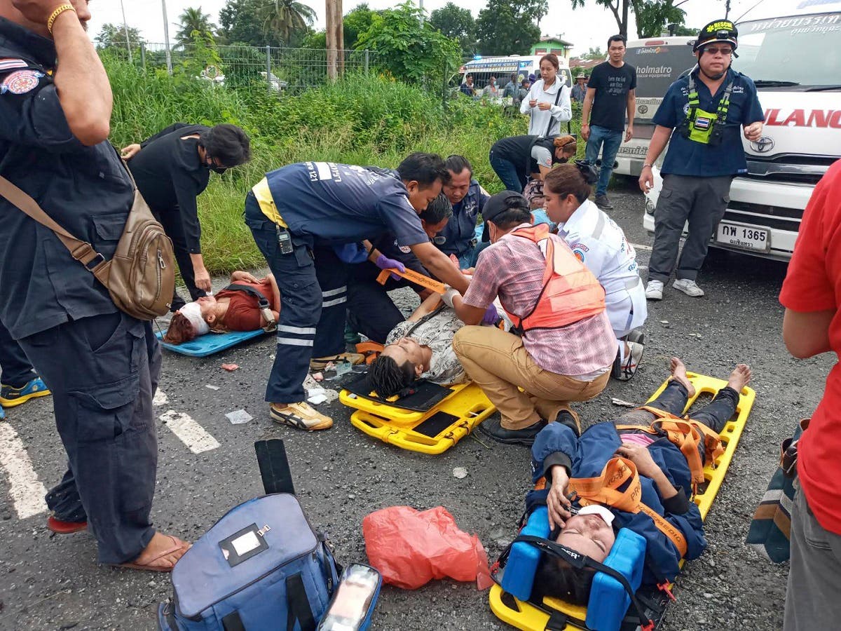 Rescuers treat injured people after a bus-train deadly collision in Thailand. (AP)