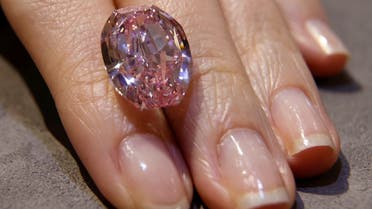 A model poses with “The Spirit of the Rose,” the world’s largest vivid purple-pink diamond, before an upcoming Geneva auction, during a Sotheby’s preview in Hong Kong, China, on October 12, 2020. (Reuters)