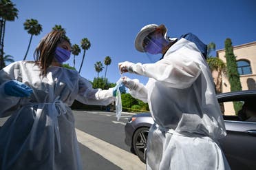 Healthcare workers collect a test sample at a drive-through coronaviurs testing center on September 29, 2020 in Los Angeles, California. (AFP)