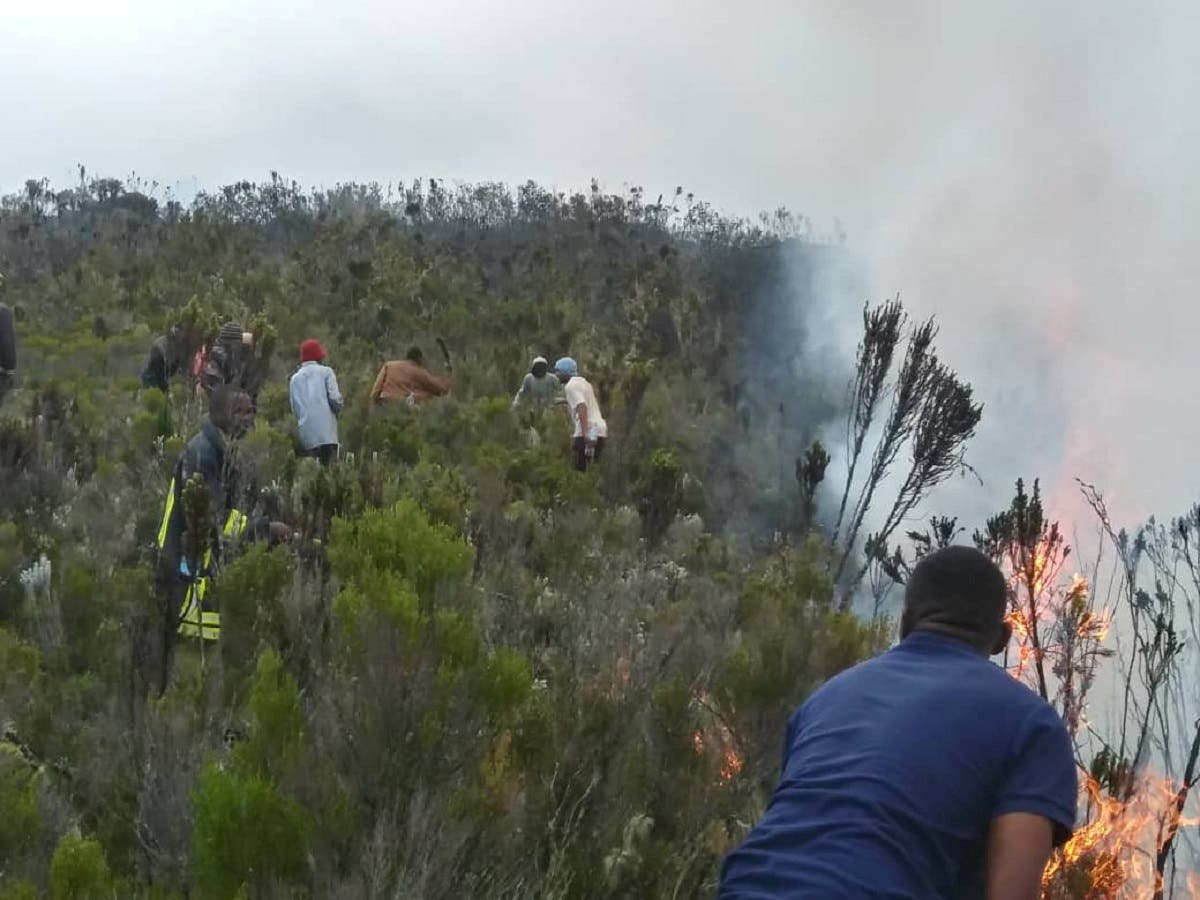 People are seen in an area as the fire spreads between Horombo camp and Mandara on Mount Kilimanjaro, Tanzania, on October 12, 2020. (Reuters)