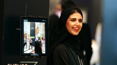 A Saudi organizer at the Future Investment Initiative conference, FII, smiles as she welcomes participants, in Riyadh, Saudi Arabia on Oct. 29, 2019. (AP)