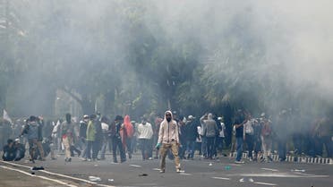 Demonstrators stand amidst tear gas during a protest against the government's labor reforms bill in Jakarta, Indonesia, on October 13, 2020. (Reuters)