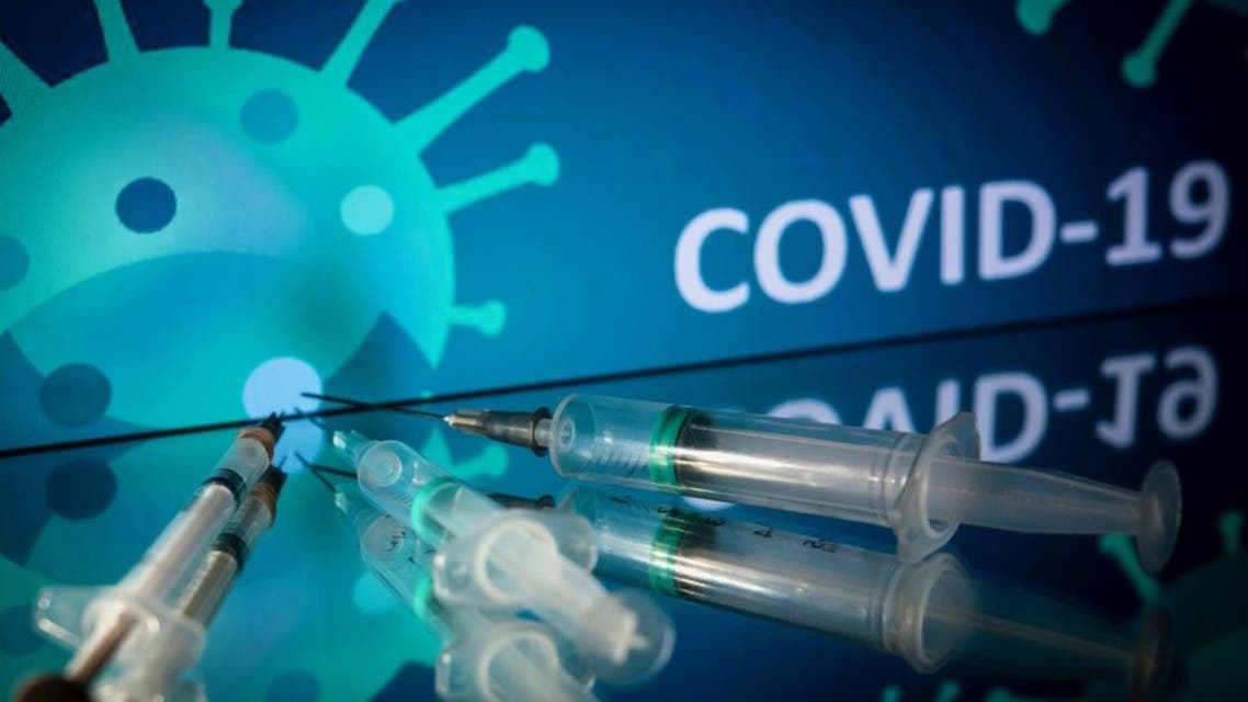 This photograph taken on October 7, 2020 shows syringes on an illustration representing coronavirus, in Toulouse, southwestern France. (AFP)
