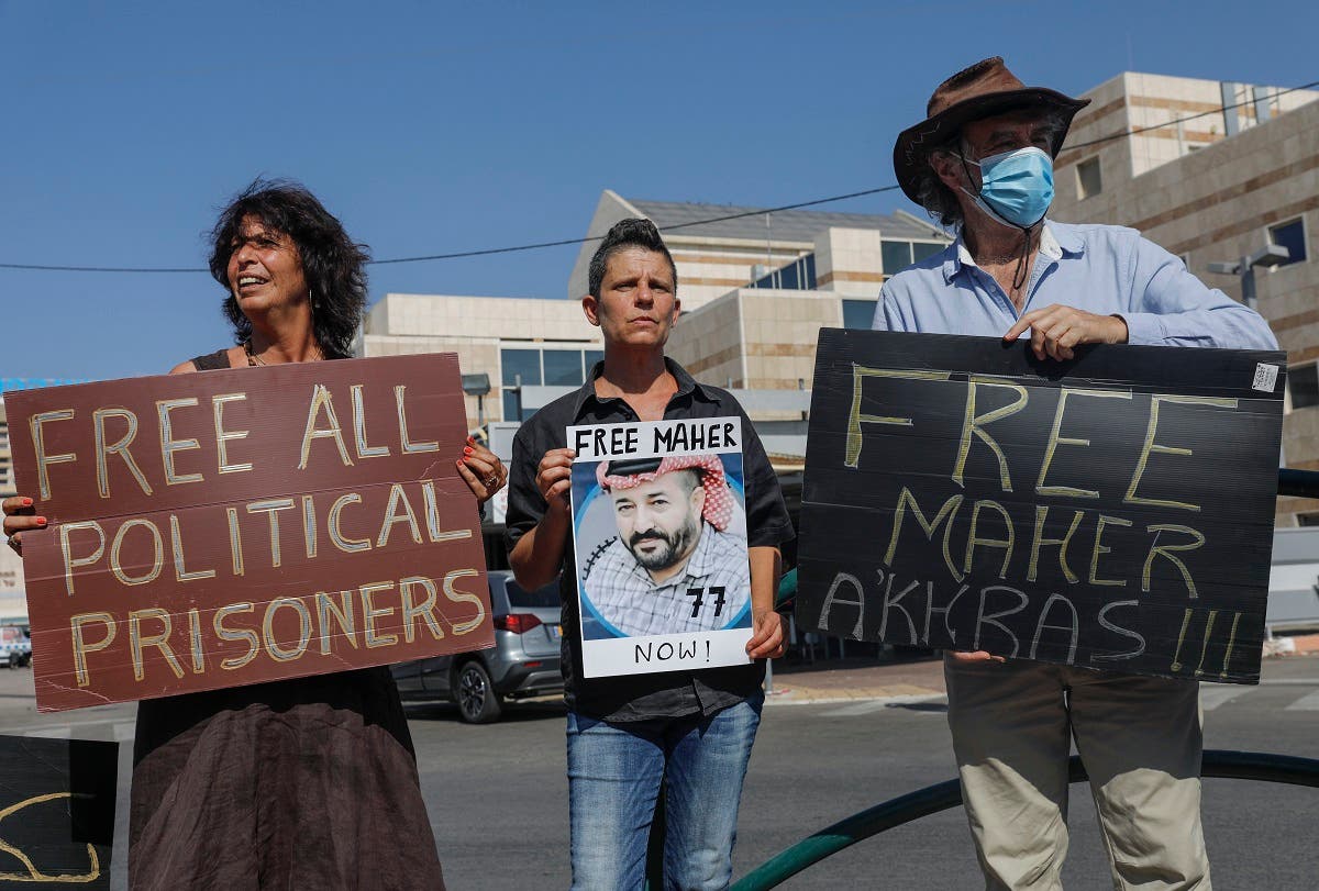 Israeli left-wing activists lift placards during a demonstration calling for the release of Palestinian administrative detainees, including Maher al-Akhras in front of Kaplan medical center in the central city of Rehovot, October 11, 2020. (Ahmad Gharabli/AFP)