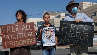 Israeli left-wing activists lift placards during a demonstration calling for the release of Palestinian administrative detainees, including Maher al-Akhras in front of Kaplan medical center in the central city of Rehovot, October 11, 2020. (Ahmad Gharabli/AFP)