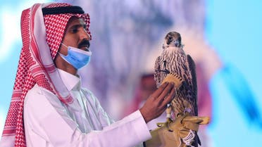 A Saudi man displays the falcon during the auction at Saudi Falcons Club Auction in King Abdulaziz Festival in Mulham, north of Riyadh, Saudi Arabia, October 13, 2020. (Media Center Saudi Falcons Club Auction via Reuters)