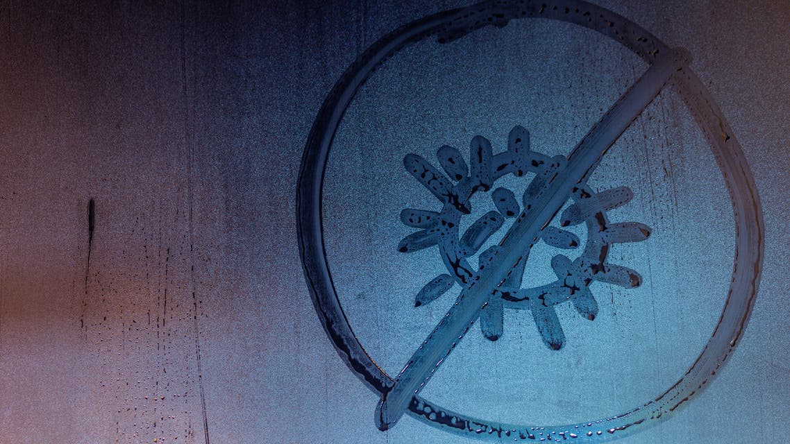 Banned coronavirus icon handwritten on night wet window glass close-up stock photo