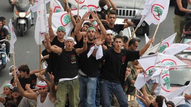 Supporters of the Lebanese Forces carry flags and shout slogans atop a bus on their way to attend a commemoration mass, Sept. 25, 2010. (Reuters)