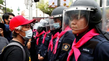 A pro-democracy protester stands in front of police officers during anti-government protests in Bangkok, Thailand, on October 15, 2020. (Reuters)