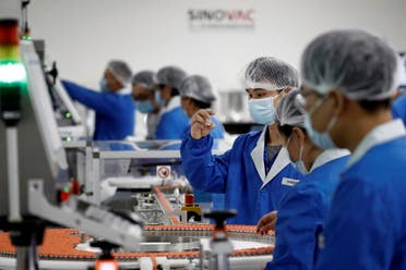 People work in the packaging facility of Chinese vaccine maker Sinovac Biotech, developing an experimental coronavirus disease (COVID-19) vaccine, during a government-organized media tour in Beijing, China, on September 24, 2020. (Reuters)