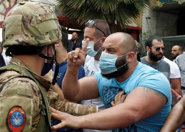 A Lebanese demonstrator gestures to a Lebanese soldier, during a protest against the collapsing Lebanese pound currency and the price hikes, in Lebanon, April 27, 2020. (Reuters)