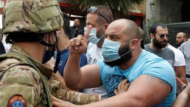 A Lebanese demonstrator gestures to a Lebanese soldier, during a protest against the collapsing Lebanese pound currency and the price hikes, in Lebanon, April 27, 2020. (Reuters)