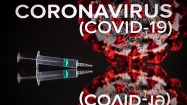 This photograph taken on October 7, 2020 shows a syringe on an illustration representing coronavirus, in Toulouse, southwestern France. (AFP)