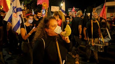 A protester blows into a shofar during a demonstration against Israeli Prime Minister Benjamin Netanyahu near his residence in Jerusalem on October 17, 2020. (Menahem kahana/AFP)